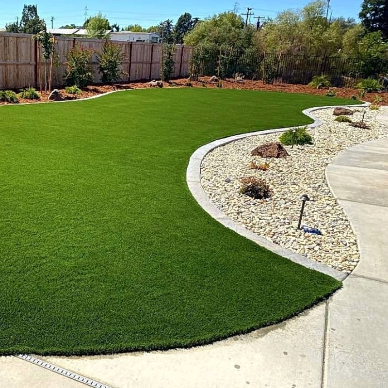 A sprinkler system in action, watering a green lawn during the early morning