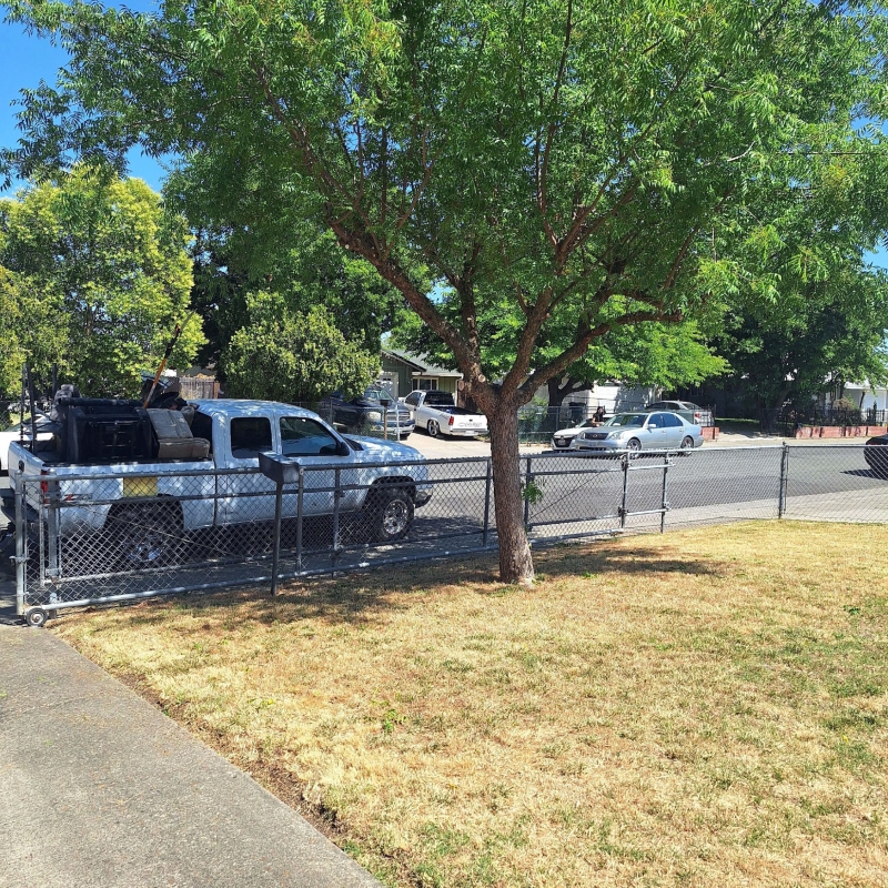 Landscaper performing fall cleanup by raking leaves from a pristine lawn